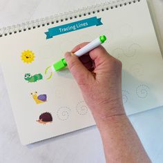 a hand holding a marker writing on a sheet of paper