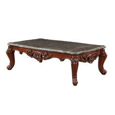 an ornately carved coffee table with marble top and wood frame, on white background