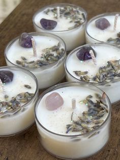 four candles with crystals in them sitting on a table