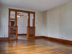 an empty room with wood floors and white walls