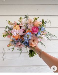 a person holding a bouquet of flowers in their hand