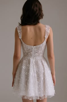 the back of a woman's dress with white flowers on it, and an open - back view