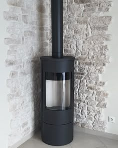 a black stove sitting in front of a brick wall next to a white and gray tiled floor