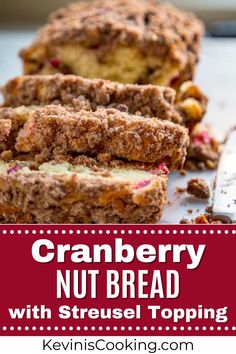 cranberry nut bread with streusel topping is cut in half on a cutting board