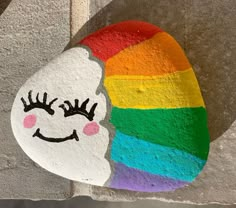 a painted rock with a rainbow face on it