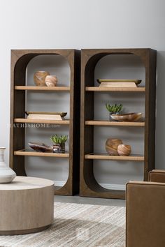 two bookshelves with vases and other items on them in a living room