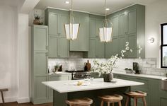 a large kitchen with green cabinets and white counter tops, along with wooden stools