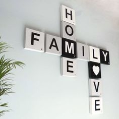 a cross made out of scrabble tiles with the words family love spelled on it