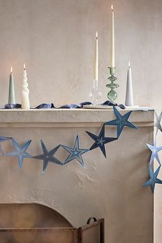 a fireplace with candles and stars hanging from it