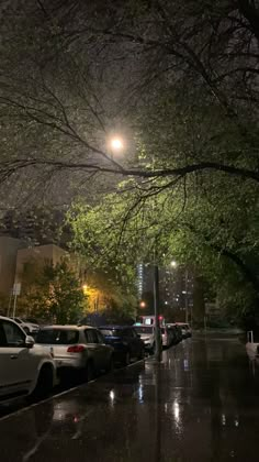 cars are parked on the side of the road at night