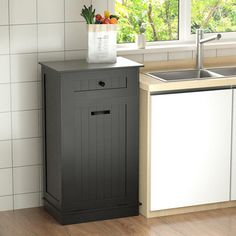 a kitchen with a sink, dishwasher and cabinet next to a window on the wall