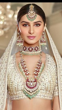 a woman wearing a bridal outfit and jewelry