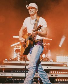 a man with a guitar on stage at a concert