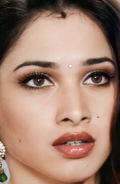 a close up of a person wearing earrings and jewelry on her head with an earring