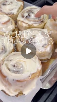 a tray filled with cinnamon rolls covered in icing