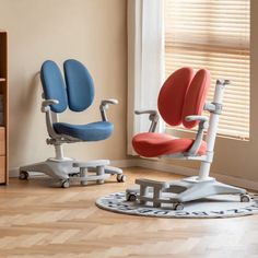 two office chairs sitting next to each other in front of a bookcase and window