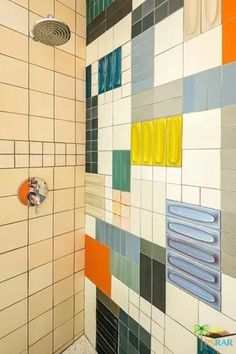 a shower with colorful tiles on the wall