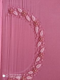 a pink cloth with white lace on it and a circle in the middle that has leaves drawn on it