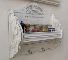 an old white shelf with jars on it