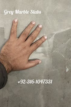 a man's hand on top of a gray marble slab with the words grey marble slabs