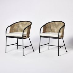 two chairs sitting next to each other on a white surface