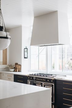 a kitchen with an oven, stove and counter tops in white painted wood paneling