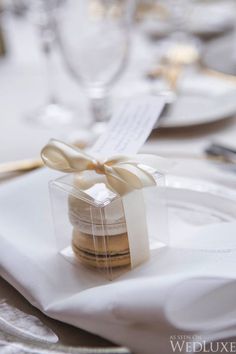 a table set with white plates and silverware, napkins and gold cutlery