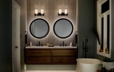 a bathroom with two round mirrors above the sinks