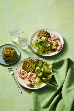 two white plates topped with food next to a glass of water and a plate of broccoli