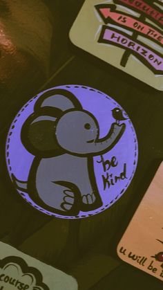 stickers on the back of a skateboard that says be kind with an image of a koala holding a sign