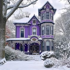 a large purple house with snow on the ground and trees in front of it,