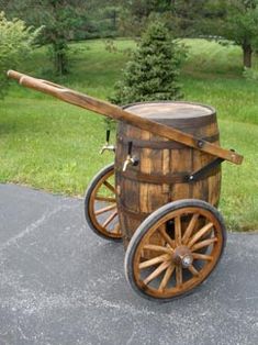 an old fashioned wooden barrel with a cannon on it's back end sitting in the middle of a driveway