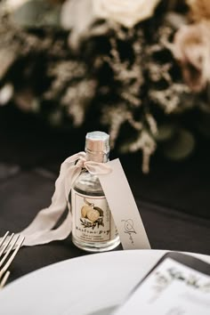 a bottle of wine sitting on top of a table next to a fork and knife