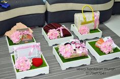 four white boxes with pink flowers in them sitting on a table next to a couch