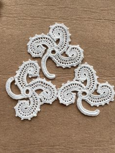 three white crocheted doily sitting on top of a cardboard box