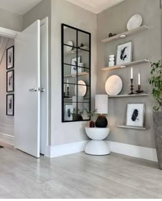 a living room filled with lots of furniture and pictures on the wall next to a doorway