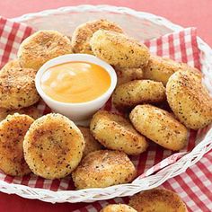 some fried food is in a white bowl on a red and white checkered tablecloth