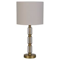 a table lamp with a white shade on the bottom and gold trim around the base