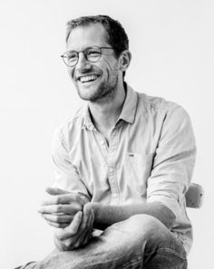 a black and white photo of a smiling man