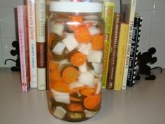 a jar filled with lots of candy sitting on top of a table next to books