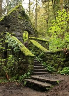 an old stone building with moss growing on it's walls and steps leading up to the entrance