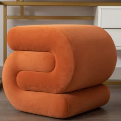 an orange chair sitting on top of a wooden floor