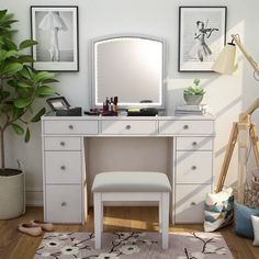 a white dressing table with a mirror, stool and potted plant next to it