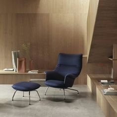 a blue chair and ottoman in front of a wooden wall