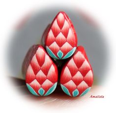 three red and turquoise colored objects are stacked on top of each other in the shape of hearts