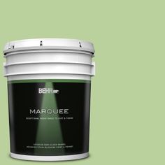 a bucket of behr marquee on a green background