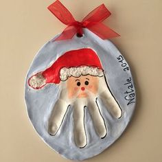 a hand painted ornament with a santa clause hat on it's palm