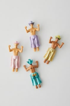 four small toy figures are placed on a white surface, including one male and one female