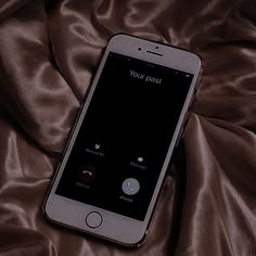 an iphone sitting on top of a bed covered in brown satines with the text your past