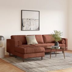 a living room with a couch, coffee table and lamp on the floor in front of it